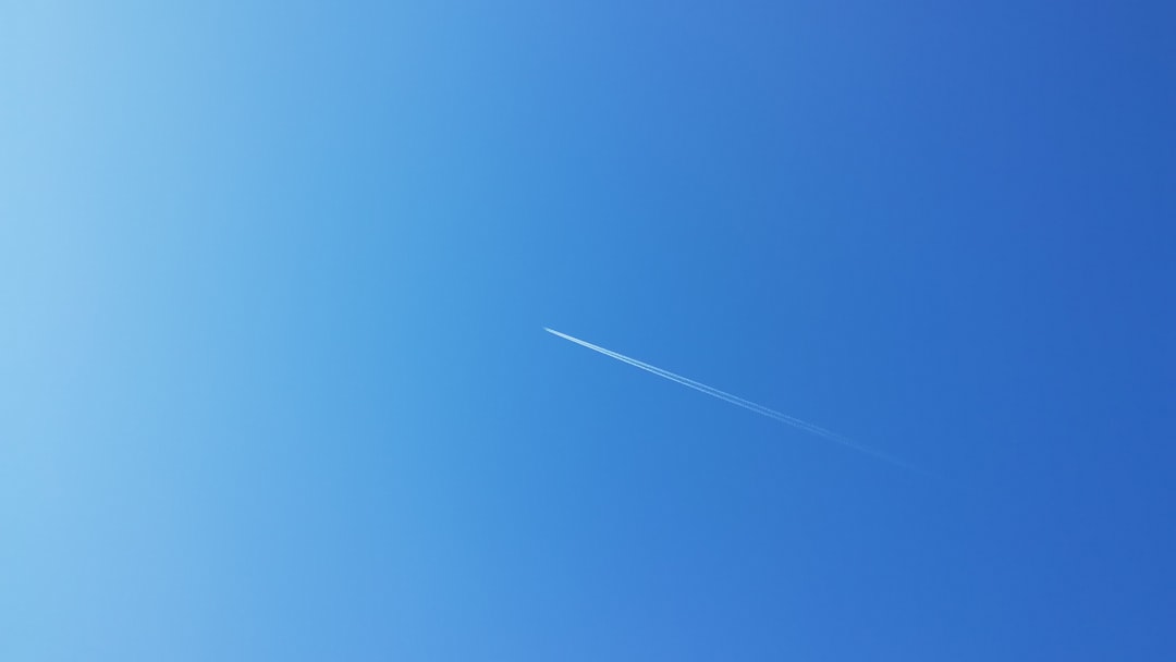 Clear blue sky with a diagonal jet contrail, illustrating the concept of "powder blue," relevant to isopod habitat color themes.